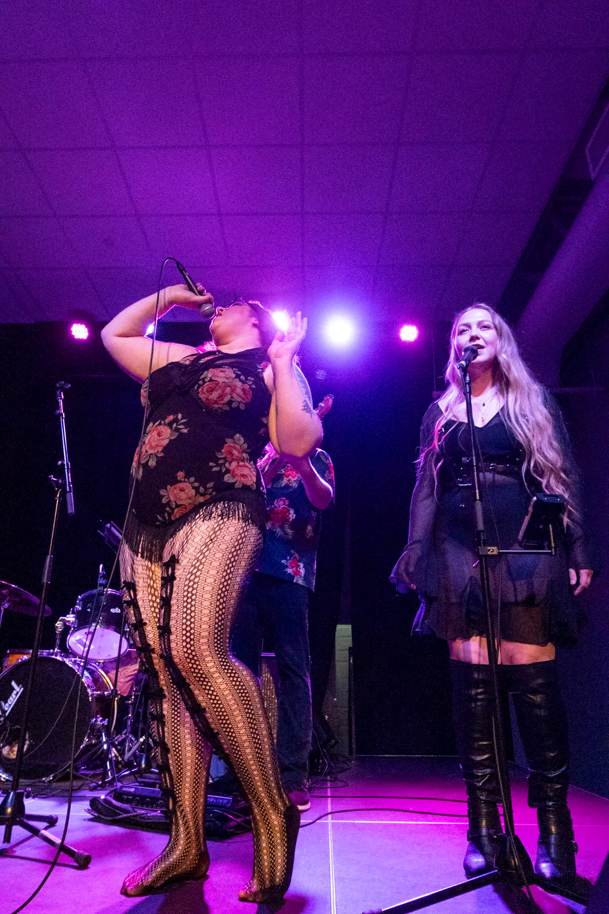 Melissa reaching up mid-note beside a backing vocalist at Mills Hardware.